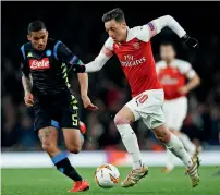  ?? Reuters ?? Arsenal’s Mesut Ozil vies for the ball with Napoli’s Allan. —