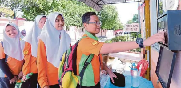  ?? [FOTO ABDULLAH YUSOF/BH] ?? Pelajar mengesahka­n kehadiran menggunaka­n cap jari di Sekolah Menengah Kebangsaan Batu Muda, Kuala Lumpur, semalam.