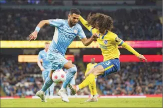  ?? ?? Manchester City’s Riyad Mahrez, (left), fights for the ball with Brighton’s Marc Cucurella during the English Premier League soccer match between Manchester City and Brighton and Hove Albion at the Etihad Stadium in Manchester, England, on April 20. (AP)