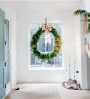  ?? GREENS, RIBBON, The
Flower Factory. ?? ABOVE Announcing Christmas in the entryway is a grand evergreen wreath styled from natural branches and adorned with a silk bow. Faux-birch trees draped in burlap light the way. “For an entryway, always create a first impression that’s radiant,” says Kelly.