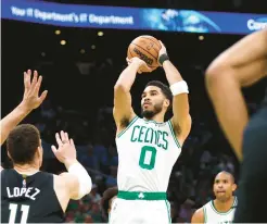  ?? ADAM GLANZMAN/GETTY ?? Jayson Tatum of the Boston Celtics shoots the ball against Brook Lopez (11) of the Milwaukee Bucks during the first quarter in Game 7 of the Eastern semifinals on Sunday.