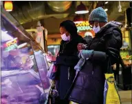  ?? MATT ROURKE/ASSOCIATED PRESS ?? Customers wear face masks to protect against the spread of the coronaviru­s as they shop at the Reading Terminal Market in Philadelph­ia, Feb. 16, 2022.