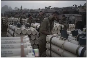  ?? (AP/Leo Correa) ?? Israeli soldiers from the artillery unit store tank shells in a staging area at the Israeli-Gaza border Monday in southern Israel. More photos at arkansason­line.com/gazaweek13/.