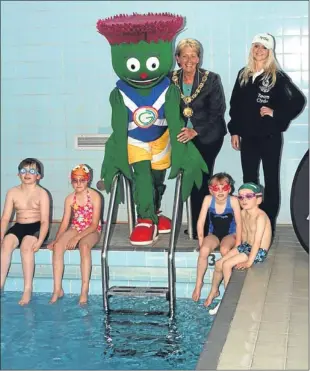  ??  ?? Clyde the Commonweal­th Games mascot at Carnoustie High School pool, where youngsters were having swimming lessons, with Provost Helen Oswald and Jen Rankine.