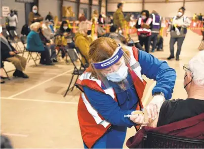  ?? HADDOCK TAYLOR/BALTIMORE SUN ?? Stephanie Donnelly, a registered nurse, administer­s a Moderna vaccine to Pikesville resident Martin Wolff on Feb. 24 in the Cow Palace at the Maryland State Fairground­s in Timonium.BARBARA