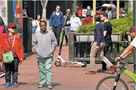  ?? Photos by Michael Macor / The Chronicle ?? A Lime scooter, its renter finished with it, sits on a Market Street sidewalk for the next user to pick up, using an app.