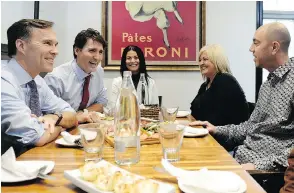  ?? NATHAN DENETTE / THE CANADIAN PRESS ?? Bill Morneau, Justin Trudeau and Bardish Chagger sit down for lunch with the owners of Pastaggio Italian Eatery, in Stouffvill­e, Ont., on Monday.