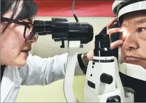  ?? GE YINIAN / FOR CHINA DAILY ?? A doctor at Aier Eye Hospital in Hefei, capital of Anhui province, examines a patient’s eyes.