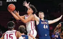  ?? Sue Ogrocki / Associated Press ?? Oklahoma’s Jalen Hill drives to the hoop past UTSA’S Luka Barisic as the Sooners scored at will Thursday night.