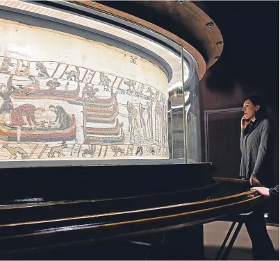  ?? AP. Picture: ?? Visitors looking at a section from the Bayeux Tapestry. French officials are considerin­g lending the historic 70m-long artefact to Britain for the first time.