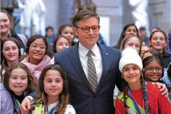  ?? AP PHOTO/YURI GRIPAS ?? House Speaker Mike Johnson, R-La., poses for a group photo with children visiting Capitol Hill on Thursday in Washington.