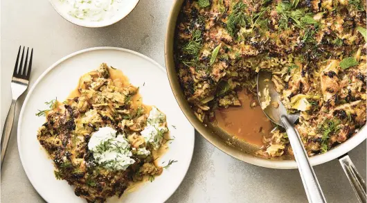  ?? ARMANDO RAFAEL/THE NEW YORK TIMES ?? A serving of pork-cabbage casserole topped with Greek yogurt and garnished with fresh dill. This recipe crosses a caramelize­d cabbage and onion saute with a lasagna-like casserole.