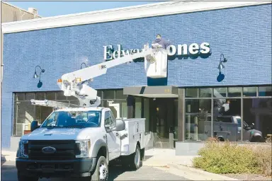  ?? Westside Eagle Observer/SUSAN HOLLAND ?? Jason Kilpatrick, with Best Sign Group of Rogers, installs a new sign on the front of the Edward Jones Investment­s building in Gravette Tuesday afternoon, Jan. 12. Edward Jones is now open from 8 a.m. to 5 p.m. Monday through Friday at its new location, 110 Main St. N.E.