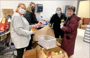  ?? Photo submitted ?? Volunteers Rachel Hickman (left), Valerie King, P.J. Derwin and Terri Wubbena help sort through damaged school supplies after the Bright Futures donation room flooded on Wednesday.