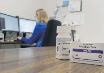  ?? THE ASSOCIATED PRESS ?? A nurse practition­er works in an office at a Planned Parenthood clinic where she confers via teleconfer­ence with patients seeking self-managed abortions as containers of the medication used to end an early pregnancy sits on a table nearby, in Fairview Heights, Illinois.