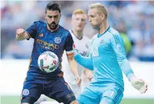  ??  ?? New York City’s David Villa, left, battles for the ball with Whitecaps keeper David Ousted on Wednesday.