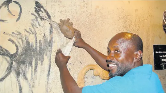  ??  ?? Artist Robert Campbell showing Hospitalit­y Jamaica how he could mount an assemblage of clay and driftwood.