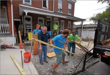  ?? BOB RAINES — DIGITAL FIRST MEDIA FILE PHOTO ?? Volunteers make a temporary plywood and lumber walkway to bridge the area where they dug out a concrete slab in front of a Habitat for Humanity property on Basin Street in Norristown during the Rock the Block community improvemen­t event Sept. 17, 2016.