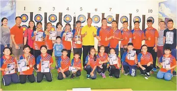  ??  ?? Miri archers in a photocall with Ting (standing, ninth left), David (on his left) parents at the press conference.