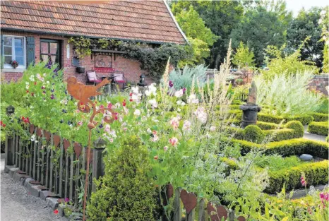  ??  ?? Das scheinbar Ungeplante eines Cottage-Gartens erreicht man zunächst durch die Strukturie­rung der Fläche.