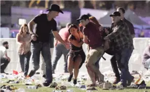  ?? | DAVID BECKER/ GETTY IMAGES ?? People carry an injured person at the Route 91 Harvest country music festival after Stephen Paddock opened fire in Las Vegas on Sunday.