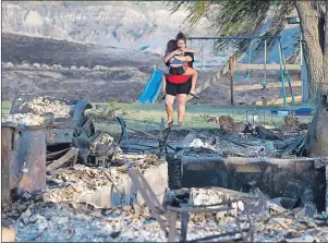  ?? CP PHOTO ?? Kelsey Thorne holds her daughter Nevaeh Porter, 8, as they both cry while viewing the remains of their home where they lived with her parents that was destroyed by a wildfire on the Ashcroft First Nation, near Ashcroft, British Columbia, late Sunday.