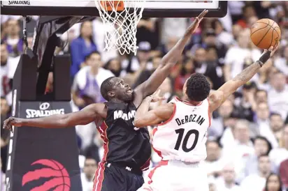  ??  ?? British basketball star Luol Deng (left) attempts to block DeRozan’s shot during the second half in Toronto