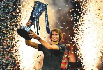  ?? AFP ?? Alexander Zverev holds up the trophy after winning the ATP World Tour Finals at the O2 Arena in London on Sunday. The German shocked Novak Djokovic 6-4, 6-3 in the final.