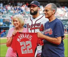  ?? CURTIS COMPTON / CCOMPTON@AJC.COM ?? Braves outfielder Nick Markakis is presented his All-Star jersey by his parents, Dennis and Mary Lou Markakis, during a pregame ceremony Tuesday. In his 13th major league season, Markakis has 2,170 hits.