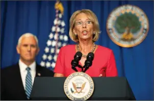  ?? The Associated Press ?? TASK FORCE: Education Secretary Betsy DeVos, with Vice President Mike Pence, speaks during a White House Coronaviru­s Task Force briefing at the Department of Education building Wednesday in Washington.