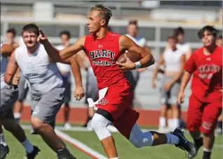  ?? Katharine Lotze/The Signal ?? Hart quarterbac­k JT Shrout looks for an opening in the defense as he goes for the quarterbac­k keeper during a scrimmage with Crescenta Valley at Hart on June 14.