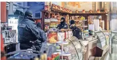  ?? FOTO: CHRISTOPH REICHWEIN ?? Polizisten durchsuche­n bei der Razzia gegen die Mafia ein Eiscafé in der Duisburger Innenstadt.