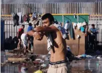  ?? Reuters ?? A migrant, part of a caravan of thousands from Central America trying to reach the United States, wrings his clothes at a temporary shelter in Tijuana, Mexico, on Tuesday.