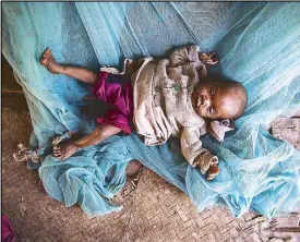  ?? EPA ?? Eight-month-old Kajy Marcelline lies on the floor at his home in Madagascar Monday. According to the United Nations, a severe food and nutrition crisis is affecting southern Madagascar.