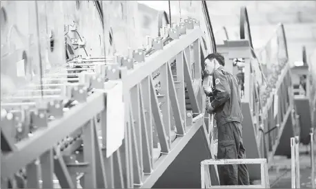  ?? PROVIDED TO CHINA DAILY ?? An employee of Xizi Otis Elevator Co Ltd assembles an escalator. Elevator and escalator sales have risen rapidly in China alongside urbanizati­on.