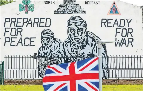  ?? PAUL FAITH / BLOOMBERG ?? La bandera britànica davant d’un mural republicà al nord de Belfast: “Preparats per a la pau, llestos per a la guerra”