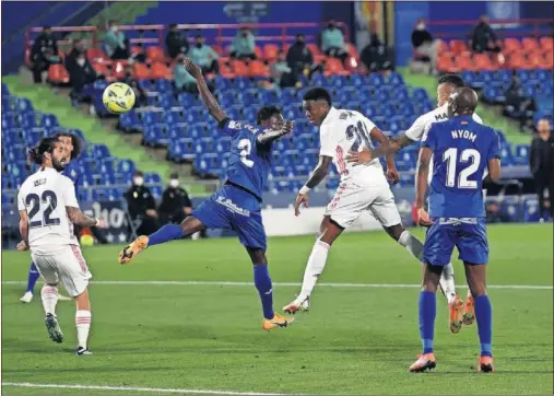  ??  ?? Vinicius remata de cabeza en el área del Getafe ante la oposición de Djené en el partido que el Madrid jugó el domingo en el Coliseum.