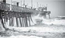  ?? JULIA WALL Raleigh News & Observer via TNS ?? The Bogue Inlet Fishing Pier in Emerald Isle, N.C., is pounded with waves as Hurricane Dorian churns up the ocean on Thursday.