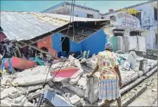  ?? Duples Plymouth / Associated Press ?? A woman stands in front of a destroyed home in the aftermath of an earthquake in Les Cayes, Haiti, Saturday.