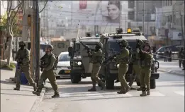  ?? MAJDI MOHAMMED — THE ASSOCIATED PRESS ?? Israeli soldiers take up positions at the scene of a Palestinia­n shooting attack at the Hawara checkpoint, near the West Bank city of Nablus, Sunday.