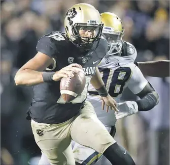  ?? David Zalubowski Associated Press ?? SEFO LIUFAU runs for a short gain against UCLA as Takkarist McKinley gives chase. Despite missing playing time because of injuries, Liufau this season has passed for 2,150 yards and rushed for almost 500.
