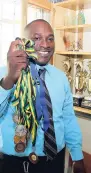  ??  ?? Clovis Menzie, principal of Newstead Primary School, St Mary shows off the medals and trophies won by the students in vairious discipline­s