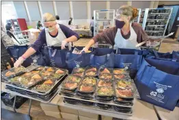  ?? Dan Watson/ The Signal ?? (Above) Volunteers Chloe Bird, left, and her mother, Linda Davies, load bags with hot meals to be handed out during the Thanksgivi­ng Drive-Thru Feast at the Bella Vida Santa Clarita Valley Senior Center on Thursday. (Below) Steven Brown and his comfort dog, 4-year-old Bailey, keep an eye on the line of vehicles. (Left) High winds blow as Susan Lawrence reads a prayer during a moment of remembranc­e for her ex-husband, Castaic Lions Club President Alan “Flo” Lawrence, co-chair of the Senior Center’s annual Thanksgivi­ng feast, who died in August.