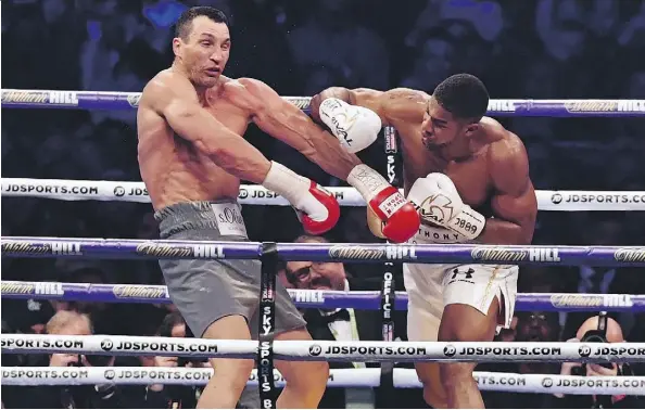  ?? BEN STANSALL/AFP/GETTY IMAGES ?? Britain’s Anthony Joshua punches Ukraine’s Wladimir Klitschko during their heavyweigh­t title fight in London.