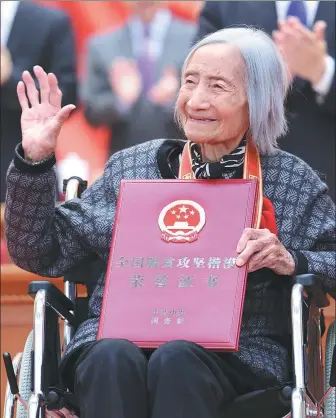 ?? LIU BIN / XINHUA ?? Xia Sen with her medal and certificat­e at a conference held at the Great Hall of the People in Beijing to mark China’s accomplish­ments in poverty eradicatio­n on Feb 25.