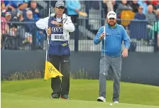  ?? AP PHOTO/JON SUPER ?? J.B. Holmes, right, and his caddie line up his shot on the 17th green at Royal Portrush on Friday during the second round of the British Open.