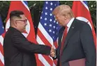  ?? ANTHONY WALLACE/AFP/GETTY IMAGES ?? North Korean leader Kim Jong Un shakes hands with President Donald Trump after their historic summit on Sentosa island in Singapore.
