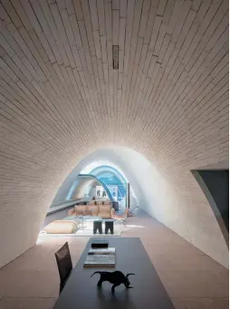  ??  ?? Above — Over the workspace, a narrow apartment runs the building's length, made from four self-supporting brick catenary vaults.