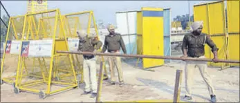  ?? BHARAT BHUSHAN/HT ?? Punjab Police personnel erecting barricades at the Ghaggar overbridge at Shambu village on the Punjab-Haryana border in Patiala on Tuesday.