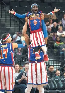  ?? DON EMMERT / AFP ?? dunks with a helping hand from his teammates during his Harlem Globetrott­ers debut on Tuesday at the Barclays Center in New York. Known as the "Michael Jordan of dwarf basketball," the 32-year-old New Yorker is proving to be a big hit with the public...